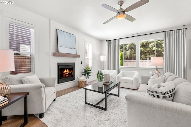 2522 S Lydia Loop, Hubbard, OR 97032 - living area featuring wood finished floors, a warm lit fireplace, and ceiling fan