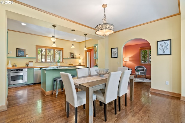 17367 Canal Cir, Lake Oswego, OR 97035 - dining room with ornamental molding, arched walkways, healthy amount of natural light, baseboards, and wood finished floors