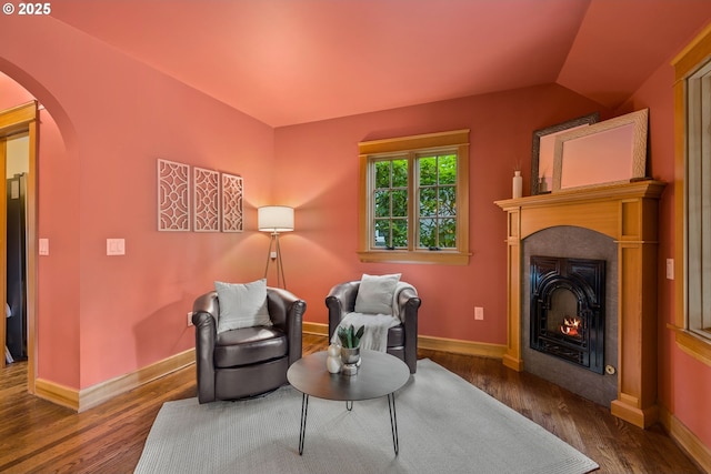 17367 Canal Cir, Lake Oswego, OR 97035 - sitting room with arched walkways, dark wood-type flooring, a warm lit fireplace, and baseboards