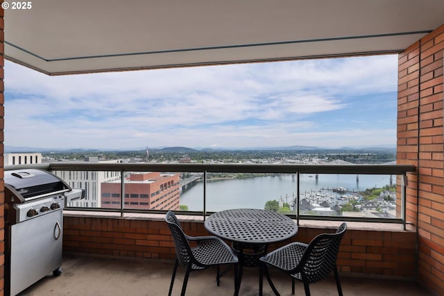 balcony with a water view and area for grilling