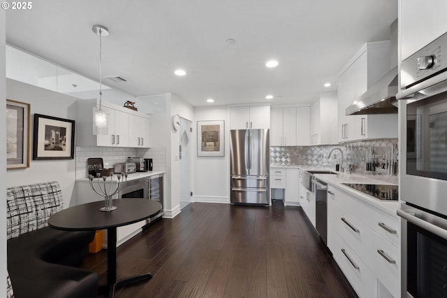 kitchen with stainless steel appliances, a sink, light countertops, backsplash, and recessed lighting