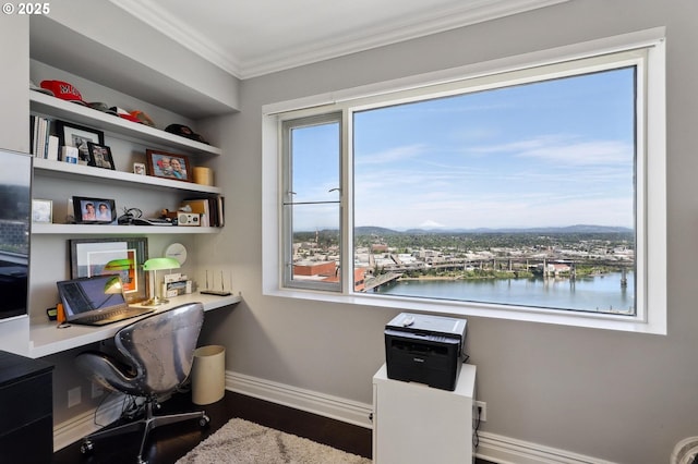 home office featuring crown molding, wood finished floors, baseboards, built in desk, and a water view