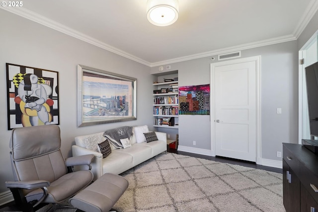 living area with crown molding, baseboards, and wood finished floors