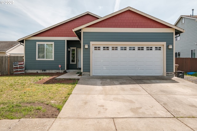 view of front facade featuring an attached garage, fence, driveway, and a front yard