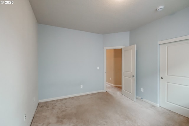 unfurnished bedroom with baseboards, a closet, and light carpet