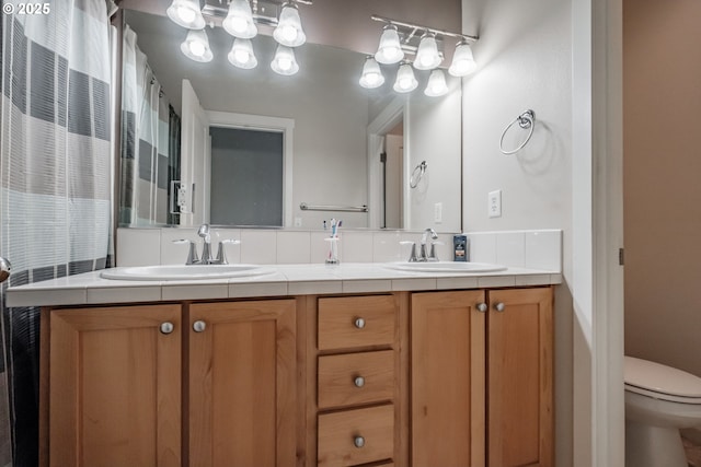 bathroom featuring a sink, toilet, and double vanity