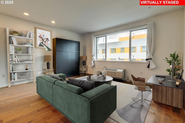 living room featuring hardwood / wood-style floors, a wall mounted air conditioner, and recessed lighting