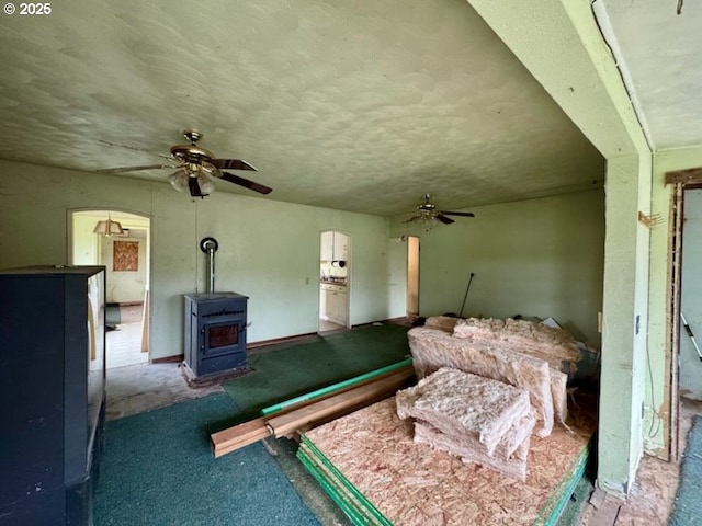 interior space with a textured ceiling and a wood stove