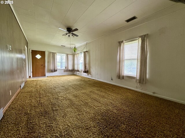 808 F Ave, La Grande, OR 97850 - carpeted empty room featuring a ceiling fan, ornamental molding, baseboards, and wooden walls