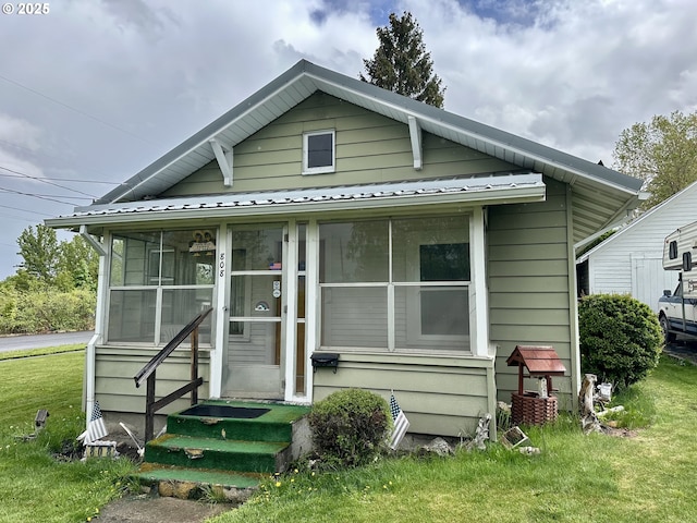 808 F Ave, La Grande, OR 97850 - view of front facade featuring entry steps, metal roof, a sunroom, and a front lawn