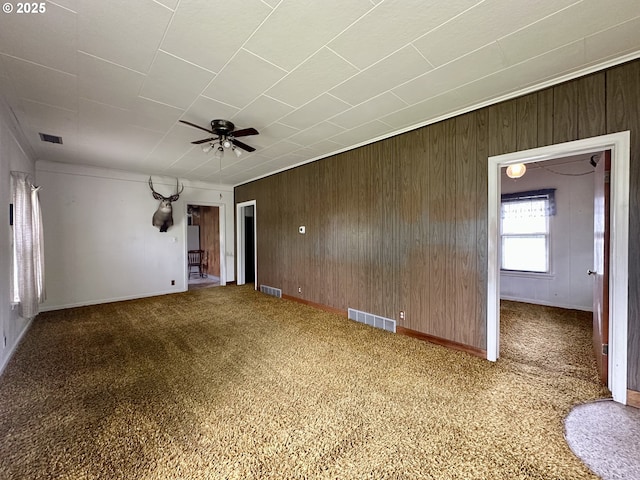 808 F Ave, La Grande, OR 97850 - empty room featuring a ceiling fan, wood walls, carpet, and baseboards