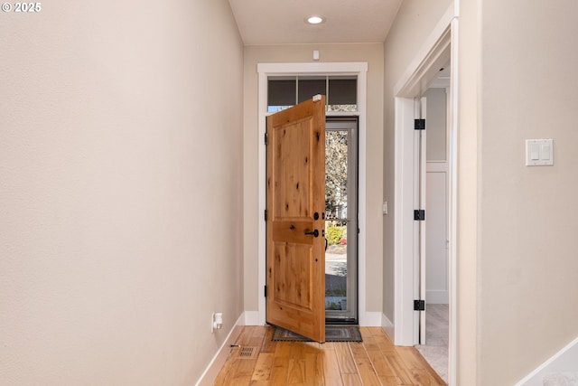 entryway featuring a wealth of natural light, light wood-type flooring, and baseboards