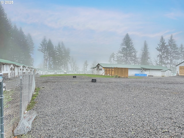 view of yard featuring an outbuilding and fence