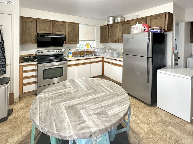 kitchen with stainless steel appliances, light countertops, and a sink