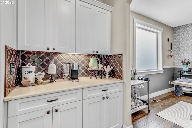 16523 NE 170th Ave, Brush Prairie, WA 98606 - kitchen featuring white cabinetry, wood finished floors, tasteful backsplash, wallpapered walls, and light stone countertops