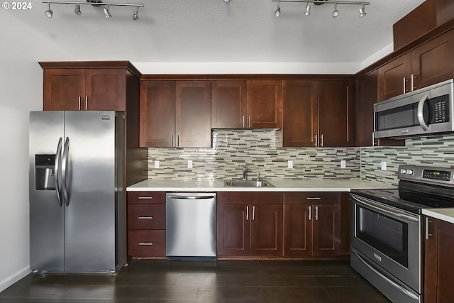 kitchen with sink, dark wood-type flooring, appliances with stainless steel finishes, and decorative backsplash