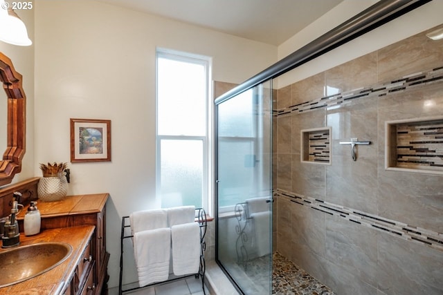 full bath with a shower stall, vanity, and tile patterned flooring