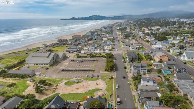 aerial view of property and surrounding area featuring expansive coastline and nearby suburban area