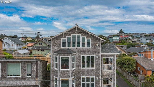 rear view of house featuring a residential view and fence