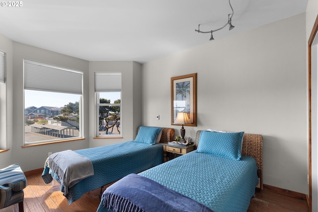 bedroom with wood-type flooring and baseboards