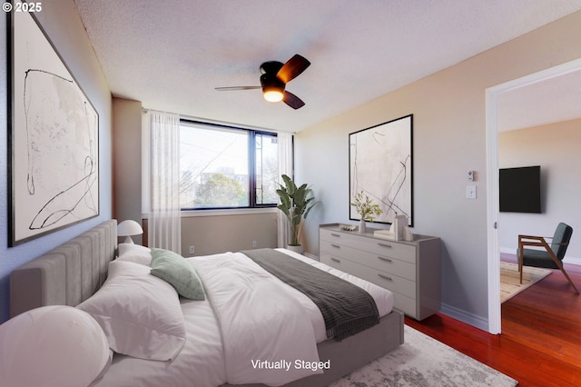 2020 SW Main St Unit 403, Portland, OR 97205 - bedroom featuring dark wood-style floors, baseboards, and a ceiling fan