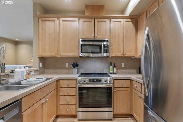 kitchen featuring tasteful backsplash, appliances with stainless steel finishes, light countertops, and light brown cabinetry