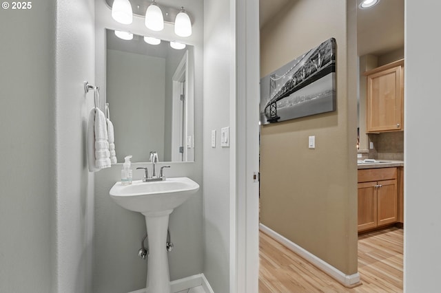 bathroom with baseboards and wood finished floors