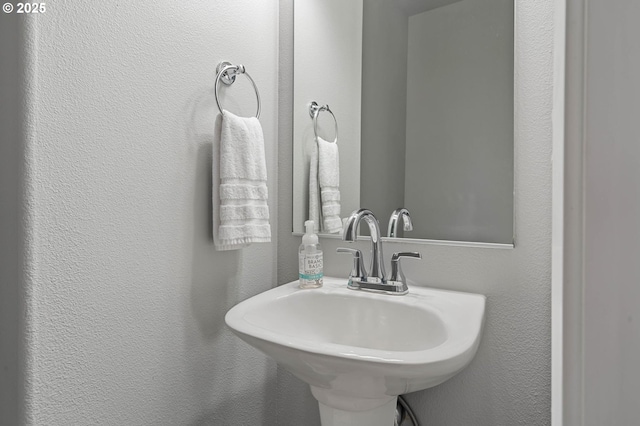 bathroom featuring a sink and a textured wall