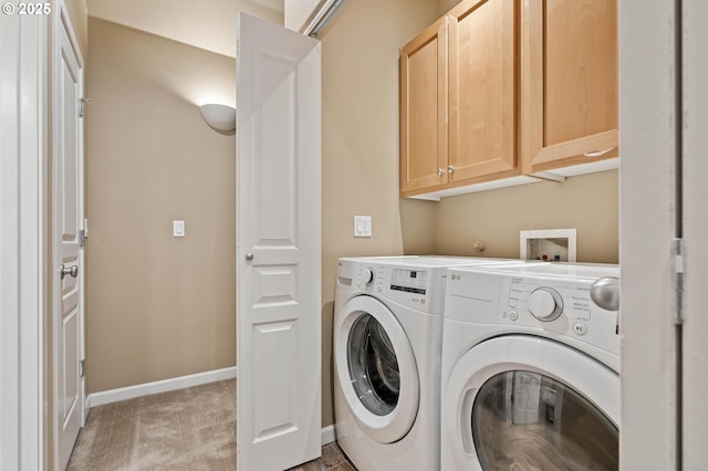 laundry room featuring light colored carpet, washing machine and clothes dryer, cabinet space, and baseboards