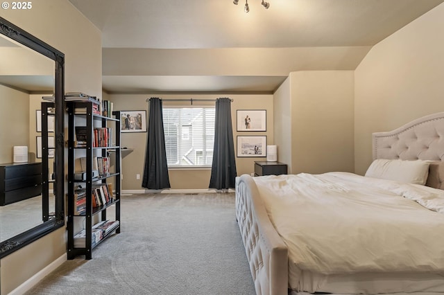 carpeted bedroom with lofted ceiling and baseboards