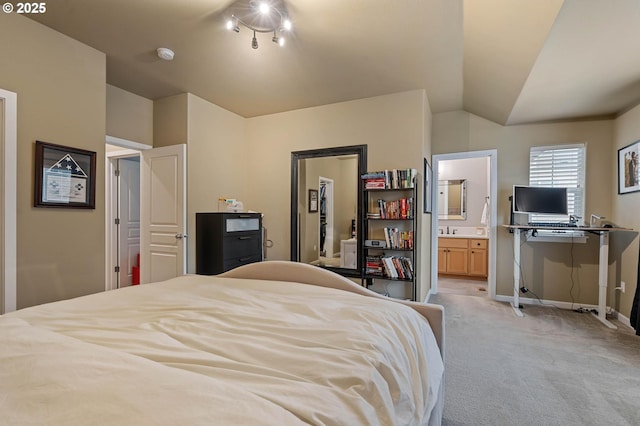 bedroom with lofted ceiling, light carpet, connected bathroom, and baseboards