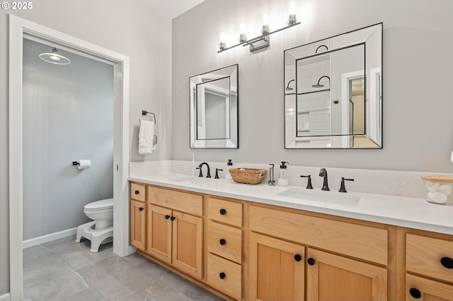 full bathroom with double vanity, a sink, and toilet