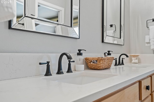 full bathroom featuring double vanity and a sink