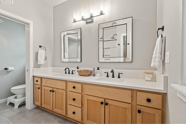 full bathroom featuring double vanity, a sink, and toilet