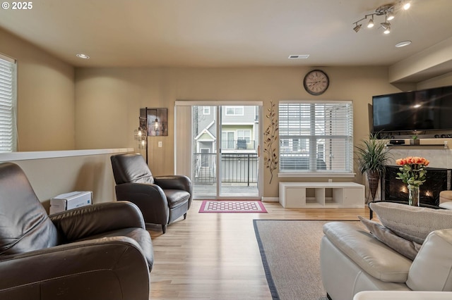 living area with visible vents and wood finished floors