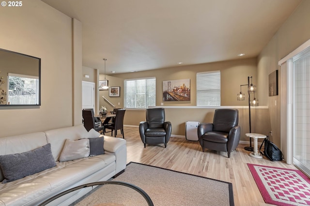 living area featuring baseboards, wood finished floors, and recessed lighting