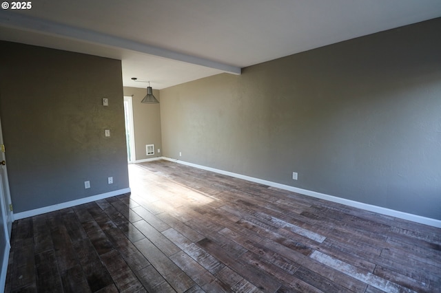 spare room with beam ceiling and dark hardwood / wood-style flooring