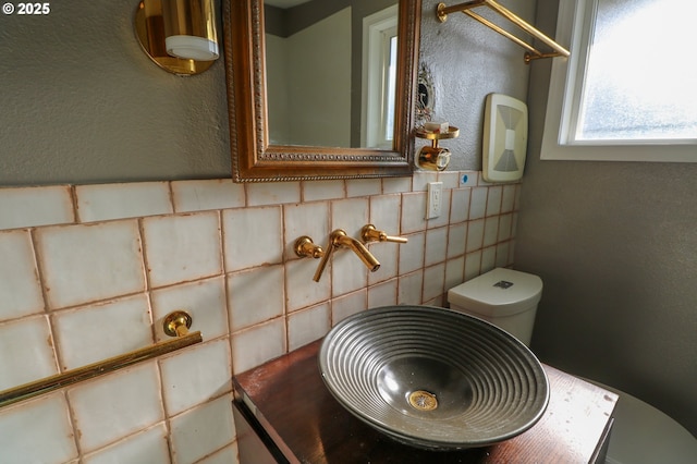 interior details featuring toilet and backsplash