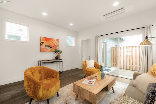 living room with visible vents, baseboards, wood finished floors, and recessed lighting