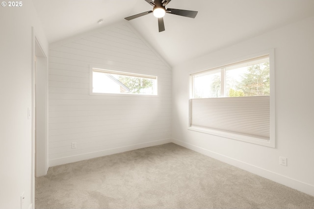 carpeted spare room with lofted ceiling, ceiling fan, and baseboards