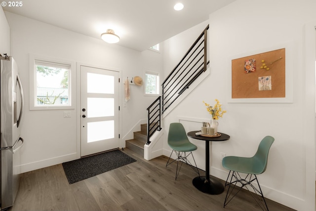 foyer entrance featuring stairs, baseboards, and wood finished floors