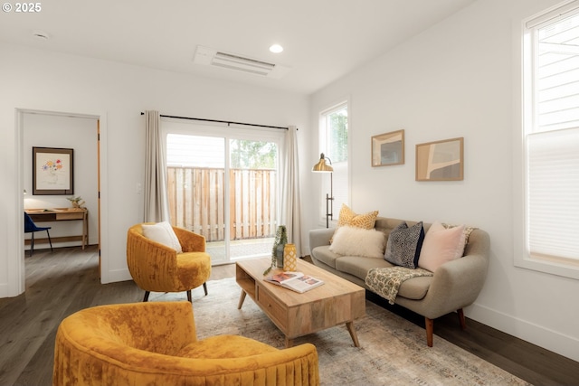 living room with visible vents, baseboards, wood finished floors, and recessed lighting