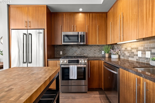 323 NW 13th Ave Unit 404, Portland, OR 97209 - kitchen with stainless steel appliances, brown cabinetry, and recessed lighting