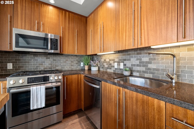 323 NW 13th Ave Unit 404, Portland, OR 97209 - kitchen featuring stainless steel appliances, brown cabinetry, and tasteful backsplash