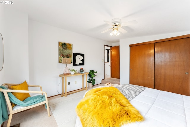bedroom with light carpet, a closet, baseboards, and a ceiling fan