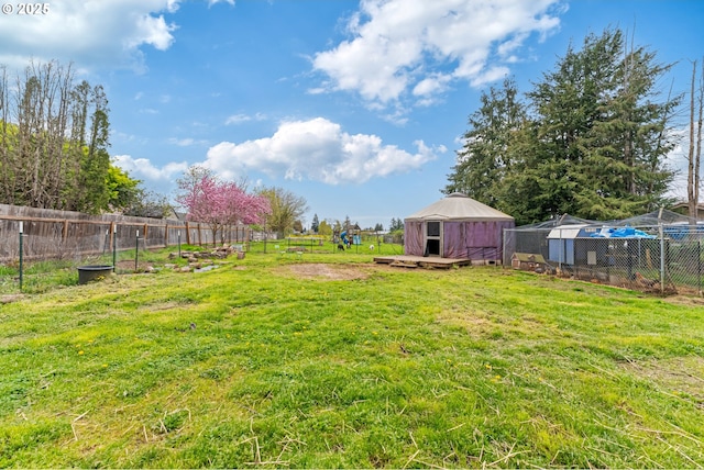view of yard with an outbuilding, fence, and exterior structure