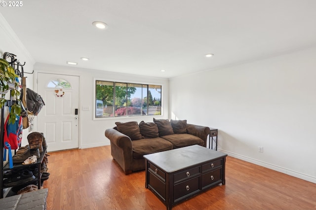 living area featuring baseboards, recessed lighting, light wood finished floors, and crown molding