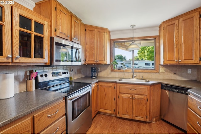 kitchen featuring brown cabinets, stainless steel appliances, and a sink