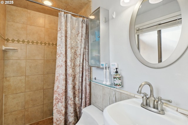 bathroom with a sink and a tile shower