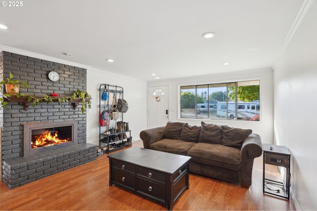 living room featuring crown molding, recessed lighting, wood finished floors, and a fireplace